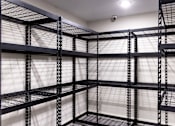 Thumbnail 36 of 50 - A series of black metal shelving units are lined up in a room.