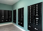 Thumbnail 26 of 50 - Three black mailboxes on a wall.