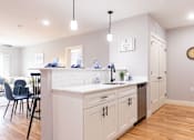 Thumbnail 4 of 50 - A kitchen with white cabinets and a wooden floor.