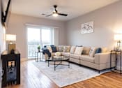 Thumbnail 2 of 50 - A living room with a beige couch, a black coffee table, and a bicycle picture on the wall.
