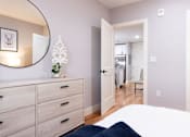 Thumbnail 13 of 50 - A bedroom with a bed, dresser, and mirror.