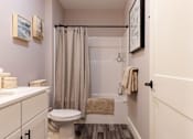 Thumbnail 46 of 50 - A bathroom with a toilet, sink, and shower.