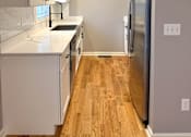 Thumbnail 28 of 53 - A kitchen with white cabinets and a stainless steel refrigerator.