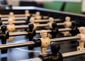 Thumbnail 14 of 24 - A close up of a foosball table with black and white players.