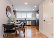 Thumbnail 8 of 57 - A modern kitchen with a dining table set for two.