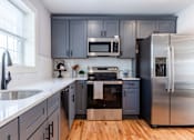 Thumbnail 2 of 60 - A kitchen with a stainless steel refrigerator and a white countertop.