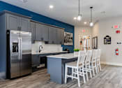 Thumbnail 11 of 24 - A kitchen with a blue wall and a stainless steel refrigerator.