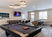 Thumbnail 47 of 57 - A pool table in a room with a television mounted on the wall.