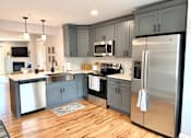 Thumbnail 71 of 71 - A modern kitchen with wooden floors and stainless steel appliances.