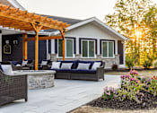 Thumbnail 23 of 24 - A patio with a table and chairs is set up outside a house.