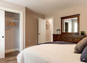 Thumbnail 17 of 31 - A bedroom with a large bed and a wooden dresser.