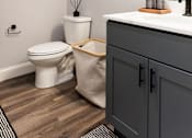 Thumbnail 76 of 78 - A bathroom with a toilet, sink, and a round wooden piece on the wall.