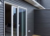 Thumbnail 74 of 78 - A grey house with a sliding glass door.