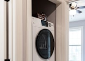 Thumbnail 8 of 60 - A white washing machine is in a cabinet.
