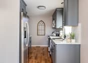 Thumbnail 3 of 53 - A kitchen with a stainless steel refrigerator and wooden floors.