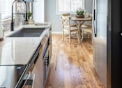 Thumbnail 1 of 53 - A modern kitchen with a black refrigerator and wooden floors.