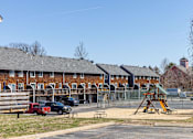 Thumbnail 46 of 53 - A playground with a slide and a building in the background.