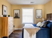 Thumbnail 22 of 34 - a bedroom with a bed and a dresser and a window