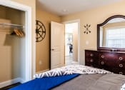 Thumbnail 27 of 34 - a bedroom with a bed and a dresser and a mirror