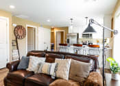 Thumbnail 6 of 34 - a living room with a leather couch and a kitchen
