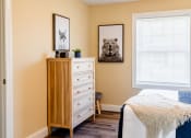 Thumbnail 23 of 34 - a bedroom with a bed and a dresser and a window