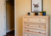 Thumbnail 24 of 34 - a bedroom with a dresser and a picture of a cat on it