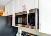 Thumbnail 12 of 34 - a kitchen with a stainless steel microwave oven and white cabinets