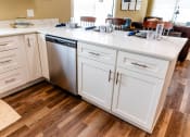 Thumbnail 10 of 34 - a kitchen with white cabinets and a stainless steel dishwasher