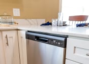 Thumbnail 14 of 34 - a stainless steel dishwasher in a white kitchen