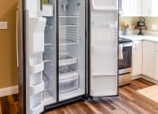 Thumbnail 13 of 34 - an empty refrigerator in a kitchen with white cabinets