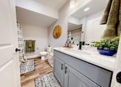 Thumbnail 69 of 71 - A bathroom with a white door and a grey cabinet.