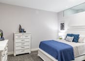 Thumbnail 102 of 106 - A bedroom with a white bed and a blue blanket.