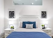 Thumbnail 94 of 106 - A bedroom with a white bed and blue bedspread.