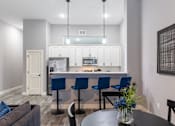 Thumbnail 99 of 106 - A modern kitchen with blue chairs and a dining table.
