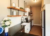 Thumbnail 6 of 8 - a kitchen with white cabinets and black counter tops