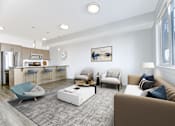 Thumbnail 7 of 30 - A modern living room with a kitchen area in the background.