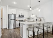 Thumbnail 1 of 103 - A kitchen with a white counter top and a stainless steel refrigerator.
