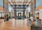 Thumbnail 57 of 99 - A modern lobby with wood floors and a glass wall.