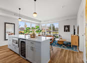 Thumbnail 6 of 99 - an open kitchen with a large island and a living room with a table and chairs
