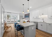 Thumbnail 111 of 113 - A kitchen with a white countertop and blue chairs.