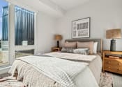Thumbnail 68 of 99 - A bedroom with a large bed and a window overlooking a cityscape.