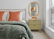 Thumbnail 113 of 113 - A bedroom with a bed, a dresser, and a mirror.