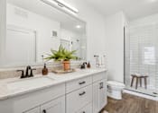 Thumbnail 6 of 103 - A bathroom with a white sink and a white toilet.