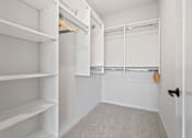 Thumbnail 16 of 99 - a walk in closet with white shelves and a white closet door