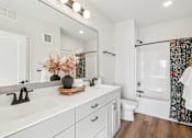 Thumbnail 76 of 99 - A white bathroom with a wooden tray on the sink.