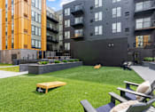 Thumbnail 101 of 103 - A modern outdoor seating area with a bench and chairs.
