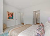 Thumbnail 18 of 99 - a bedroom with a bed and a door to a bathroom