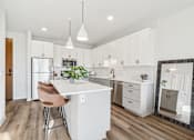 Thumbnail 62 of 99 - A kitchen with a white island and a refrigerator.