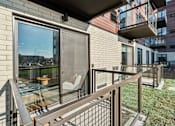 Thumbnail 73 of 99 - A balcony with a table and chairs overlooking a cityscape.