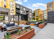 Thumbnail 85 of 103 - A patio area with a black table and chairs in front of a building.